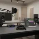 Câble XLR mâle-femelle BSN posé sur une table de studio avec micro, ordinateur portable et enceintes audio